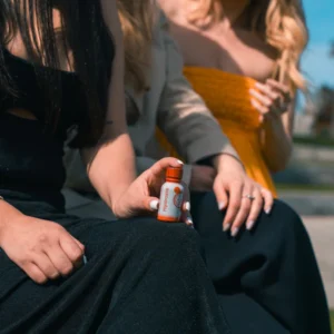 hand holding Hydroxie Kratom Pseudo Shot on knee